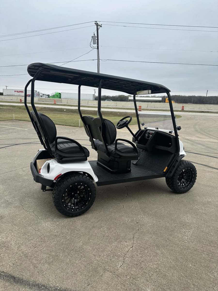 Black and white golf cart with a roof and four seats.